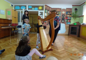 Dzieci oglądają z bliska harfę.